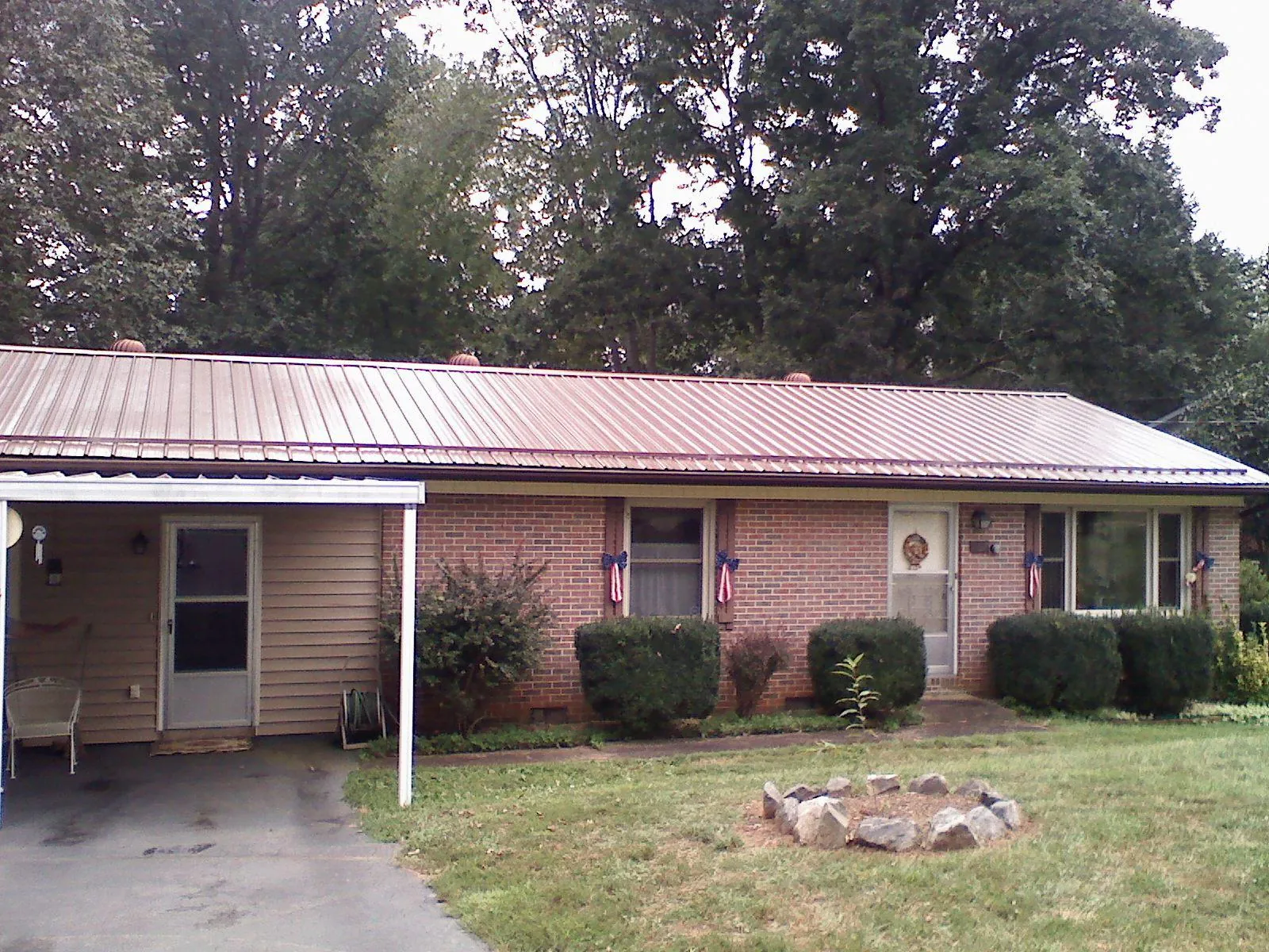 Bronze metal roof and carport on a brick ranch home — Roof Repair work by our crew in Gautier