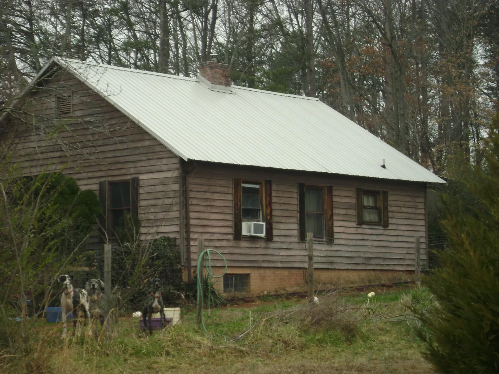 White metal roof on an old wood sided farmhouse, from a Metal Roof Installation job in Gautier